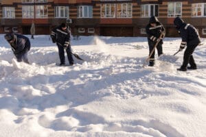 Moscow. Russia. Winter 2020. Four Janitors Wave Their Shovels In