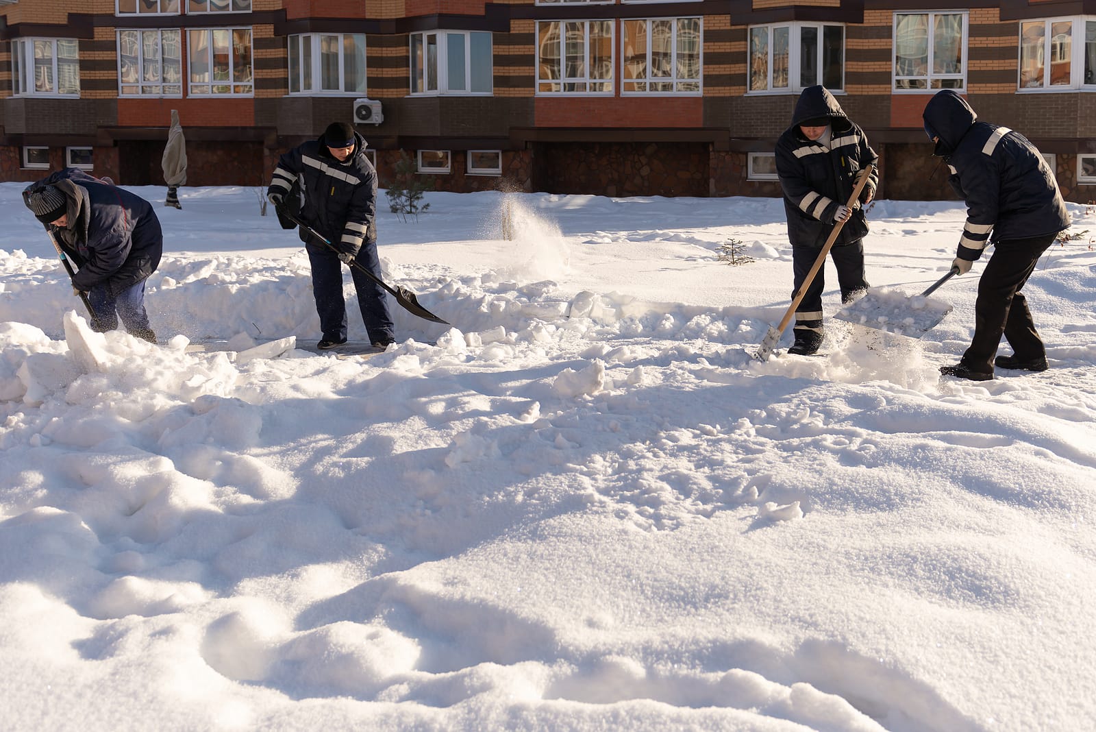 Moscow. Russia. Winter 2020. Four Janitors Wave Their Shovels In